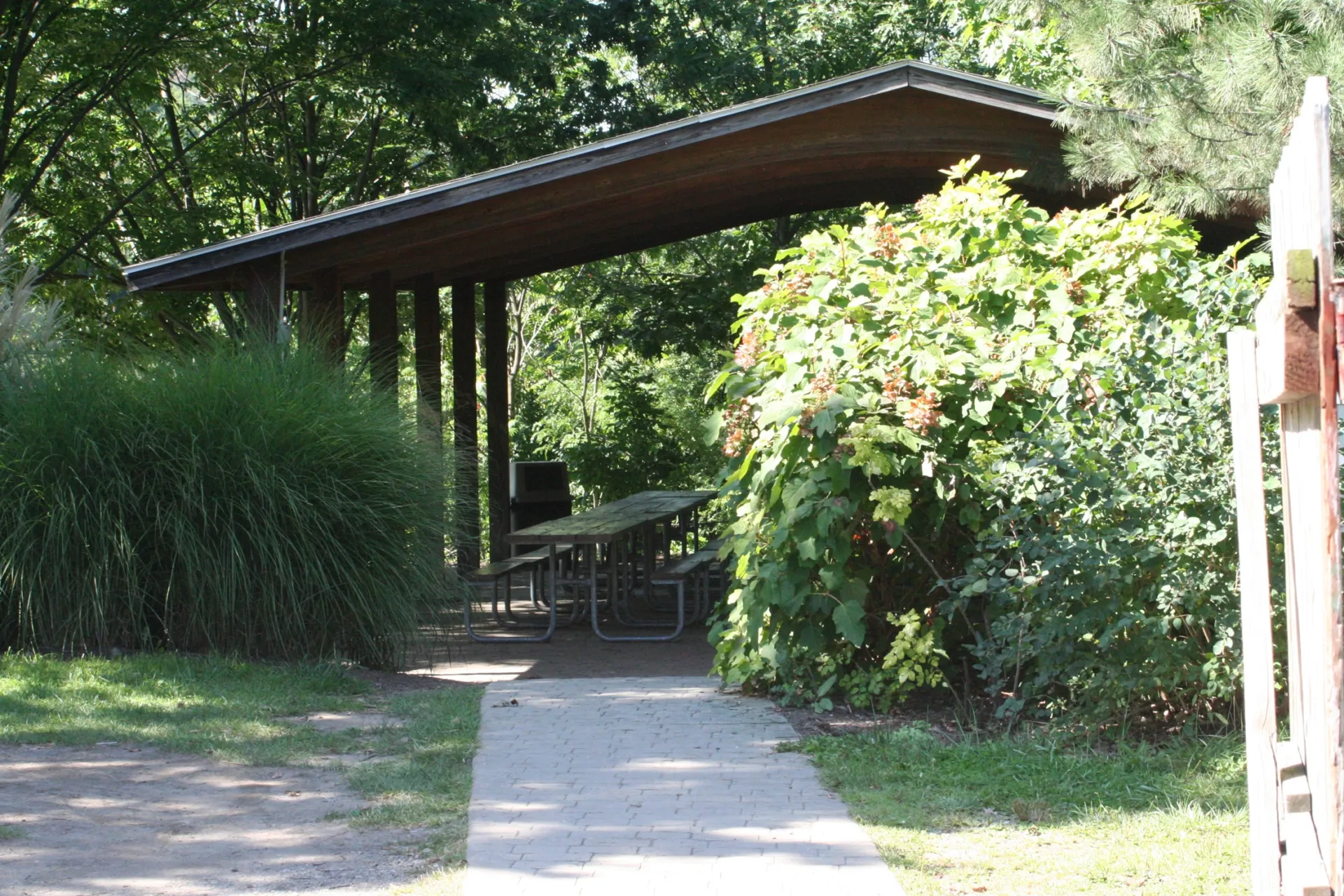 Pittsburgh Zoo village pavilion with picnic tables inside and surrounded by greenery.