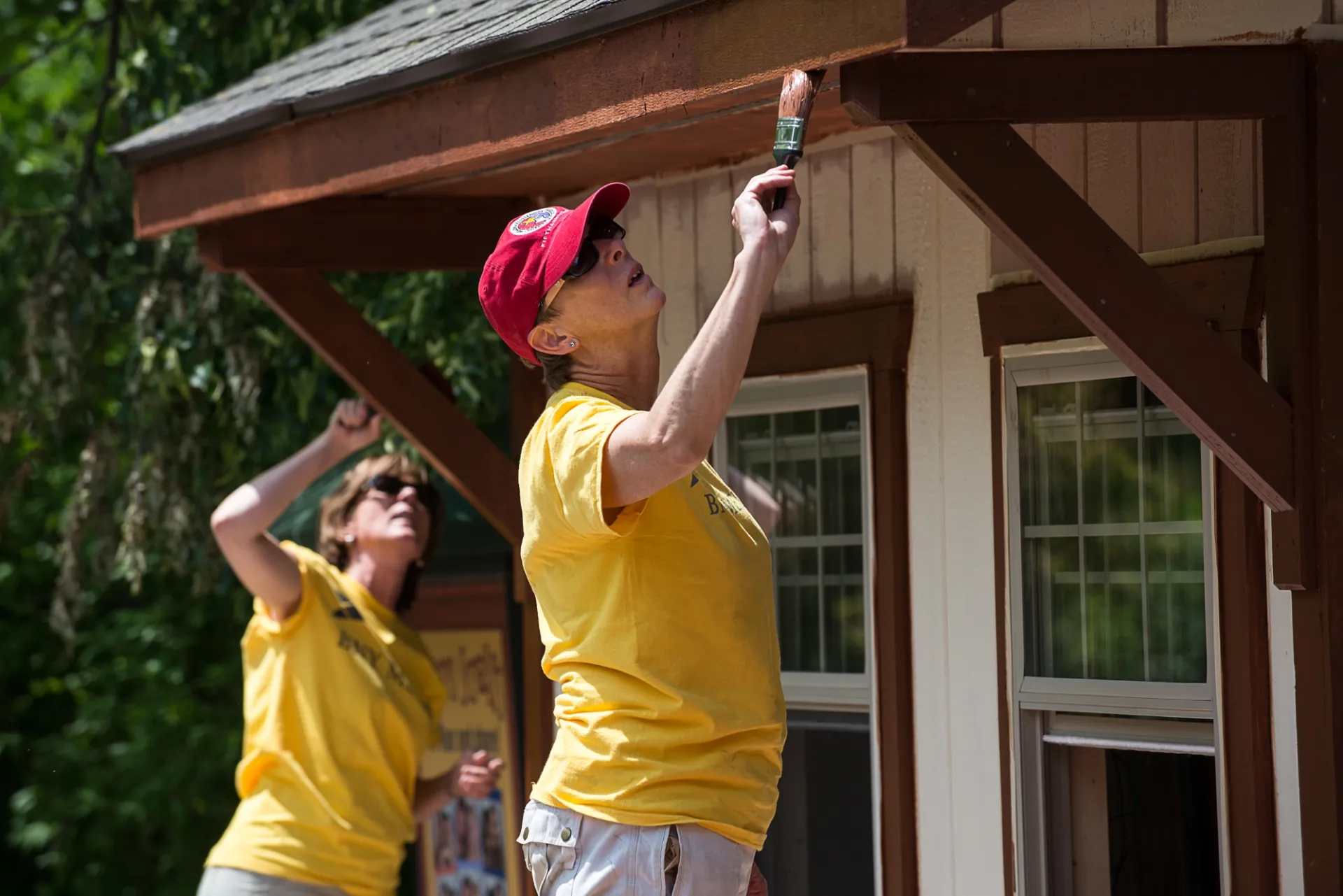 Two Zoo volunteers painting.