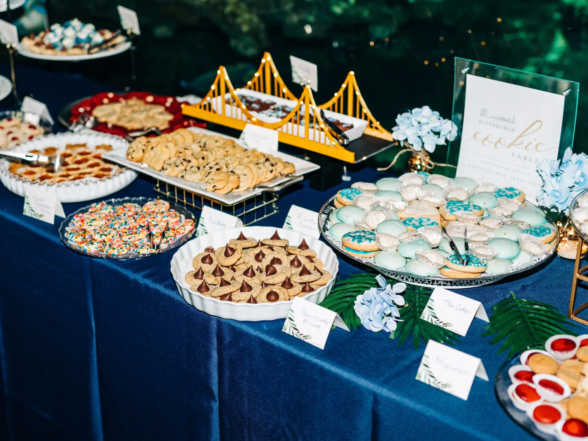 a pittsburgh cookie table at a wedding. some cookies are displayed on a bridge-shaped display table.