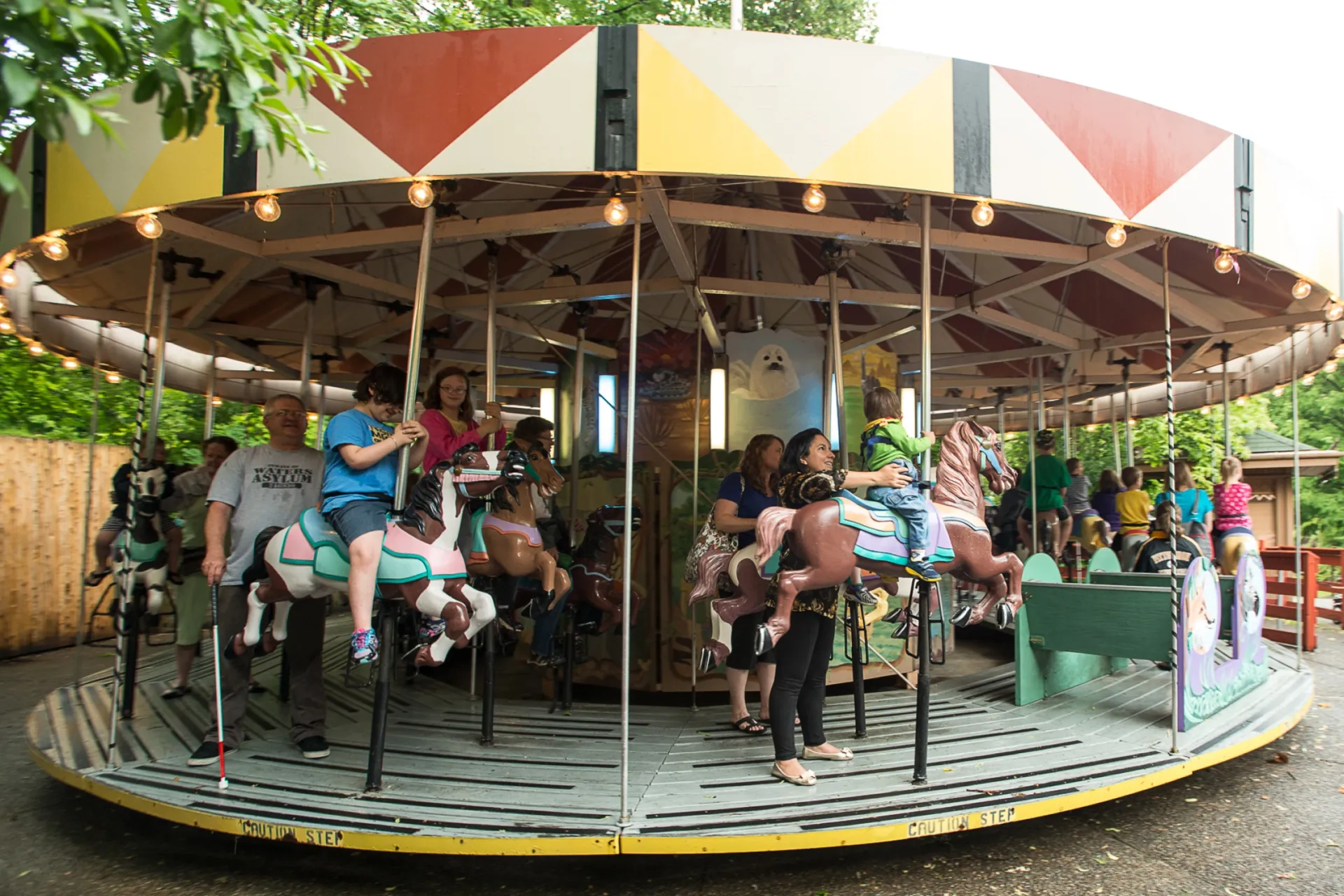 Children and their parents riding the Zoo's carousel.